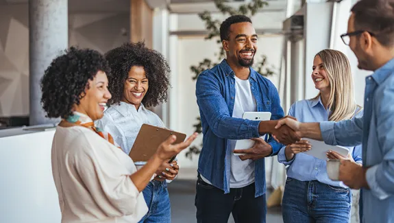 Group of educators shaking hands.