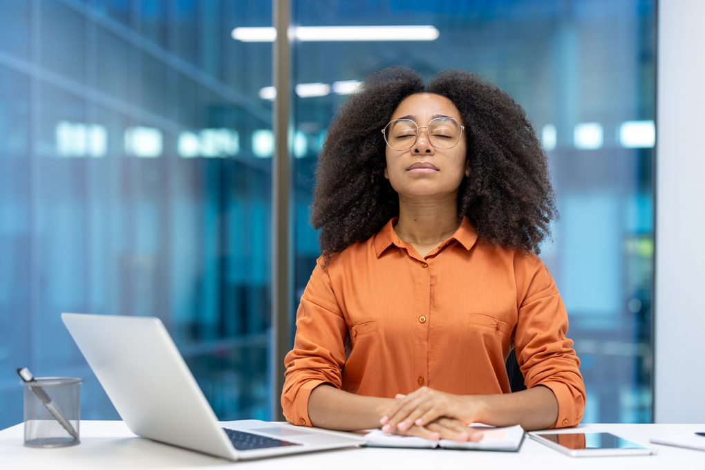 Woman deep breathing in her quiet office