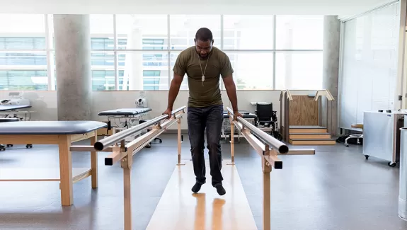 Man practicing physical therapy with bars