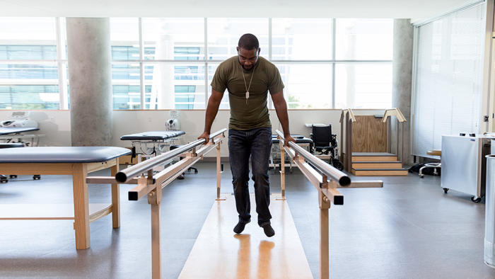 Man practicing physical therapy with bars