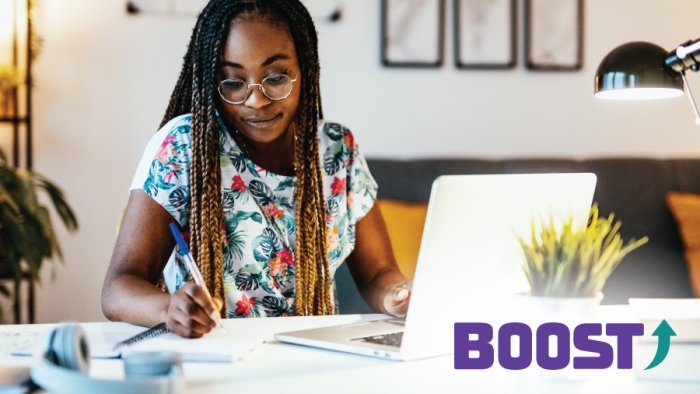 Student taking notes next to laptop, BOOST ABA Pro Builder