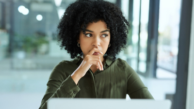 Woman looking concerned in front of laptop