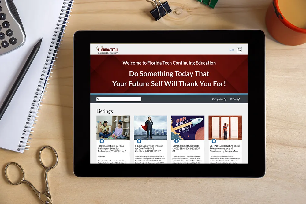 Tablet on desk with Florida Tech course catalog visible